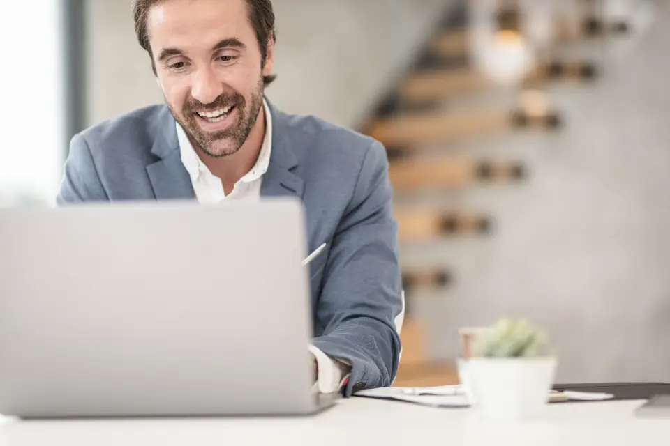 Un expert-comptable souriant devant son ordinateur