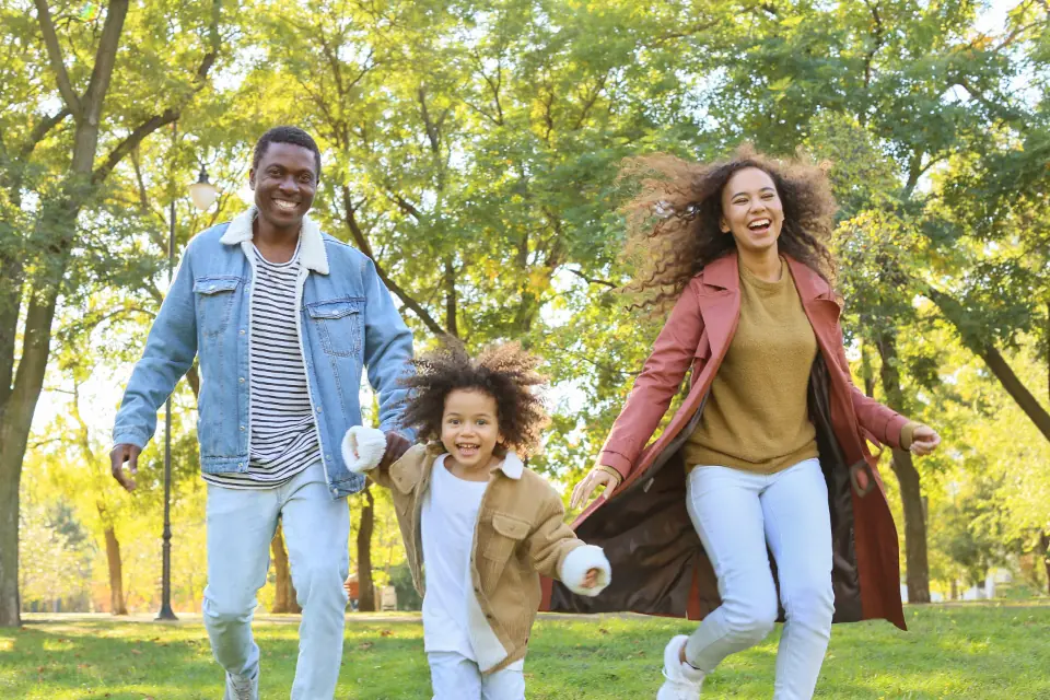 Une famille court en riant dans un parc