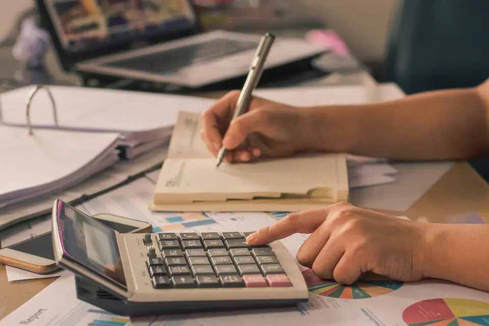 Mains sur une calculatrice et des pièces comptables