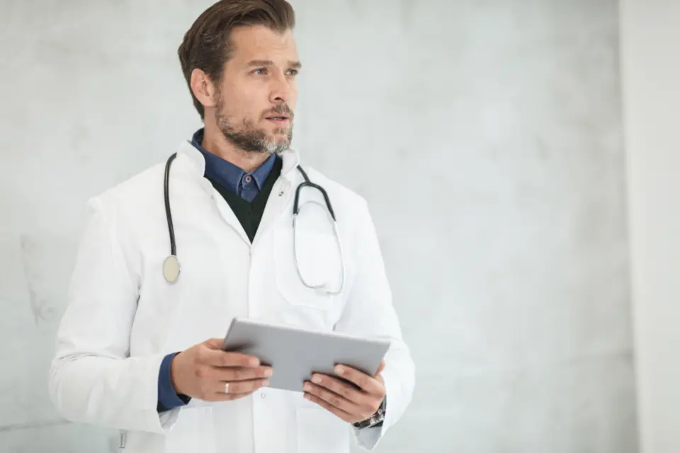 Un médecin en blouse blanche consulte une tablette