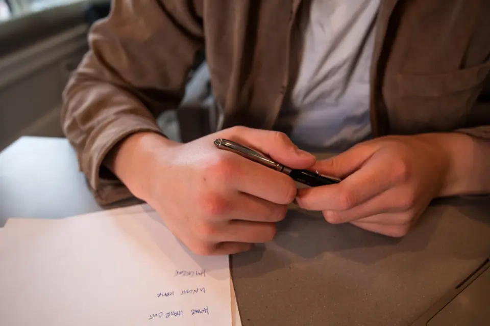 Des mains relisent un acte, stylo en main