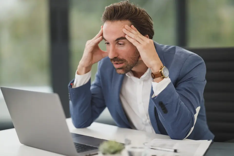 Un avocat se prend la tête devant son ordinateur